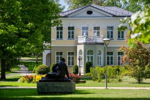 a statue in front of a large building at Europa Royale Druskininkai in Druskininkai