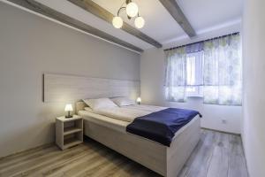 a bedroom with a large bed and a window at FRAJDA Domki - Apartamenty 6-osobowe - salon i dwie sypialnie oraz Studia 4-osobowe - pokój z aneksem kuchennym in Rewal