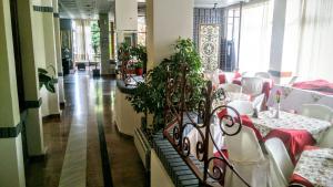 a dining room with tables and chairs and plants at Hotel Villa Tasko in Drama