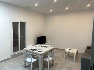 a living room with a table and chairs and a couch at Floriana Cosy Corner in Il-Furjana