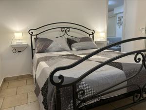 1 cama negra en un dormitorio con 2 lámparas en Appartamento Stella marina, en Pesaro