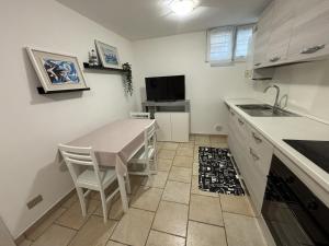 Una cocina con una mesa, un fregadero y una encimera. en Appartamento Stella marina, en Pesaro 2 fotos más