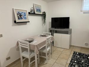 Un comedor con una mesa y un televisor. en Appartamento Stella marina, en Pesaro