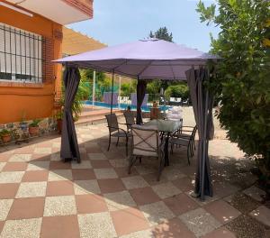 a table and chairs under an umbrella on a patio at Villa huetor Cerca de sierra Nevada in Huétor Vega