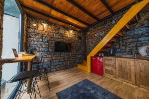una stanza con un muro di pietra e un frigorifero rosso di Tree Bungalov Maşukiye a Kartepe