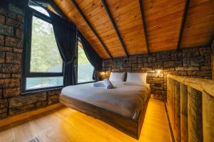 una camera da letto con un letto in una stanza con finestre di Tree Bungalov Maşukiye a Kartepe Altre 47 foto