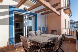 einen Holztisch und Stühle auf dem Balkon eines Hauses in der Unterkunft Marina II by Ĥ - Marina Isla Canela PMHII27P65 in Punta del moral