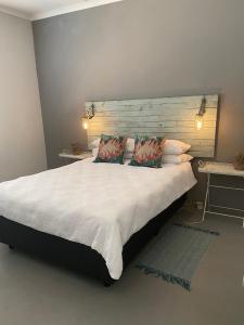 a bedroom with a large white bed with two pillows at Arendsnest in Springbok