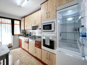 eine Küche mit Küchengeräten aus Edelstahl und Holzschränken in der Unterkunft VUT Plaza Fontana in Salamanca