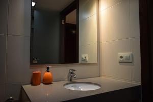 a bathroom sink with a mirror and an orange bottle on it at CASA PETRA in Morella +14 photos