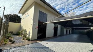 a building with a black door and a patio at Lux Ville - Apartamento aconchegante no centro de Foz in Foz do Iguaçu