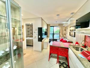 a kitchen with red chairs and a living room at Landscape Beira-Mar Perfect in Fortaleza