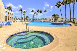 a swimming pool at a resort with palm trees at Canalfront Port Isabel Cottage 5 Mi to Beach! in Port Isabel