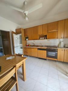 a kitchen with wooden cabinets and a table in it at Casa Yuliya in Letojanni +49 photos