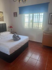 sypialnia z łóżkiem z białą pościelą i oknem w obiekcie Villa Natalia, Benajarafe w mieście Vélez-Málaga