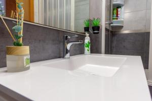 a white sink in a bathroom with a mirror at Mar Vista Home in Ponta Delgada +32 photos