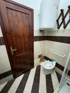 a bathroom with a toilet and a sink and a door at Casa vacanza La Sciumara in Palau +39 photos