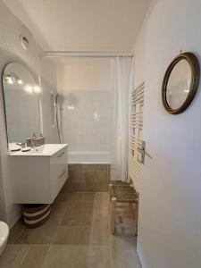 a white bathroom with a sink and a mirror at Studio centre ville- Grand balcon-Meublé BoConcept in Cavalaire-sur-Mer +25 photos