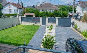 a backyard with a fence and a grass yard at Appartement du Plateau - Proche Disney in Pontault-Combault