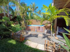 un patio trasero con piscina y palmeras en Les cabanes éco-responsables, en Saint-Louis