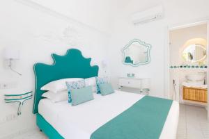 a white bedroom with a blue and white bed at Villa Nannina in Positano