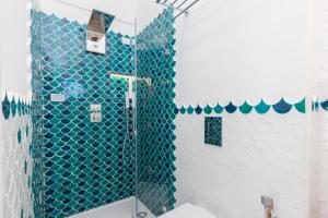 a bathroom with a shower with blue tiles at Villa Nannina in Positano