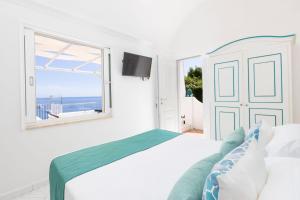 a white bedroom with a bed and a window at Villa Nannina in Positano