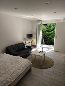 een woonkamer met een bed, een bank en een tafel bij City-Apartment in Dortmund