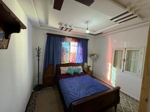 ein Schlafzimmer mit einem Bett mit blauen Laken und einem Fenster in der Unterkunft Maison oudelaou in Oued Laou + 10 Fotos