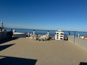 Eine Terrasse mit Stühlen und dem Meer im Hintergrund in der Unterkunft Maison oudelaou in Oued Laou