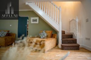 a living room with a chair and a staircase at Relaxing Ironbridge Hot Tub Retreat in Ironbridge
