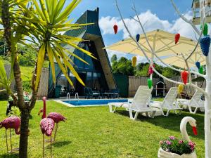 a garden with flamingos in front of a building at Banderabungalov in Kartepe +7 photos