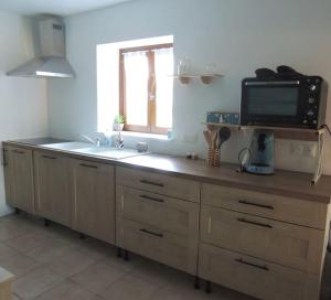a kitchen with a sink and a tv on a counter at La Séliniére ! in Champ-du-Boult