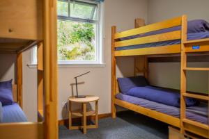 克里安拉利Crianlarich Youth Hostel的有两张双层床和一张桌子的房间
