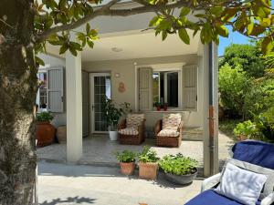a patio with two chairs and a tree at Pesciolino Rosso in Cesenatico