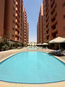 a large blue swimming pool in front of some buildings at Royal Suite near City Star Mall 3 Bedroom Apart in Cairo