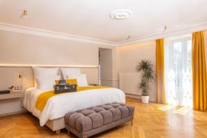 a large bedroom with a large bed and a chair at Le Clos Alice - Hôtel et Spa, Arbois in Arbois +62 photos