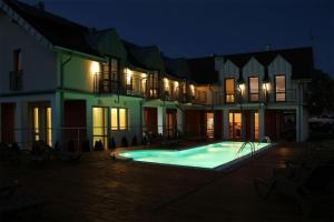 a house with a swimming pool at night at FRAJDA Dom Wypoczynkowy in Rewal