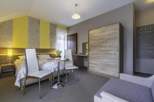 a bedroom with a bed and a table and chairs at FRAJDA Dom Wypoczynkowy in Rewal