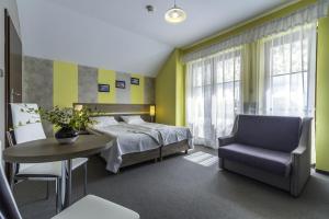a bedroom with a bed and a table and a chair at FRAJDA Dom Wypoczynkowy in Rewal +22 photos