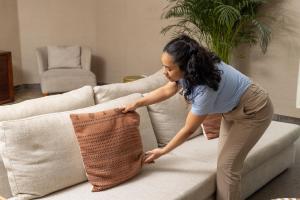 a woman putting a pillow on a couch at Hotel Baltum in Albufeira