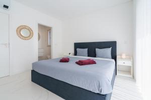 1 dormitorio con 1 cama grande y 2 toallas rojas. en Villa Venus with jacuzzi and private pool, en Lourinhã