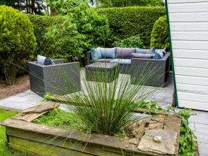 a garden with two chairs and a couch and sidx sidx sidx at COZY & SPACIOUS PLACE ON A QUIET SPOT IN THE MIDDLE OF THE NETHERLANDS with free use of 2 women's and 2 men's bikes plus child seat in Putten