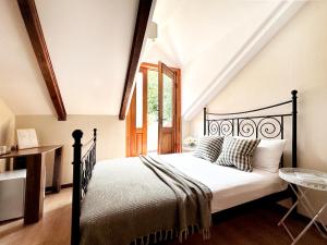 a bedroom with a black bed in a attic at Betlemi Old Town Hotel in Tbilisi City