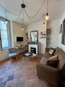a living room with a couch and a fireplace at Côté Escaliers - Cosy appartement au cœur de Blois in Blois