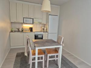 a kitchen with a table and chairs and a refrigerator at Terrace Apartments at Kirkkokatu in Savonlinna +9 photos