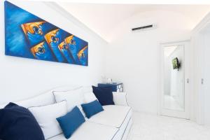 a white living room with a white couch with blue pillows at Villa Nannina in Positano