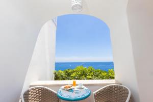 a table and chairs in front of a window with the ocean at Villa Nannina in Positano