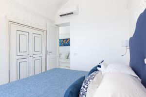 a bedroom with a blue and white bed and a door at Villa Nannina in Positano