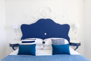 a blue and white bed with blue and white pillows at Villa Nannina in Positano
